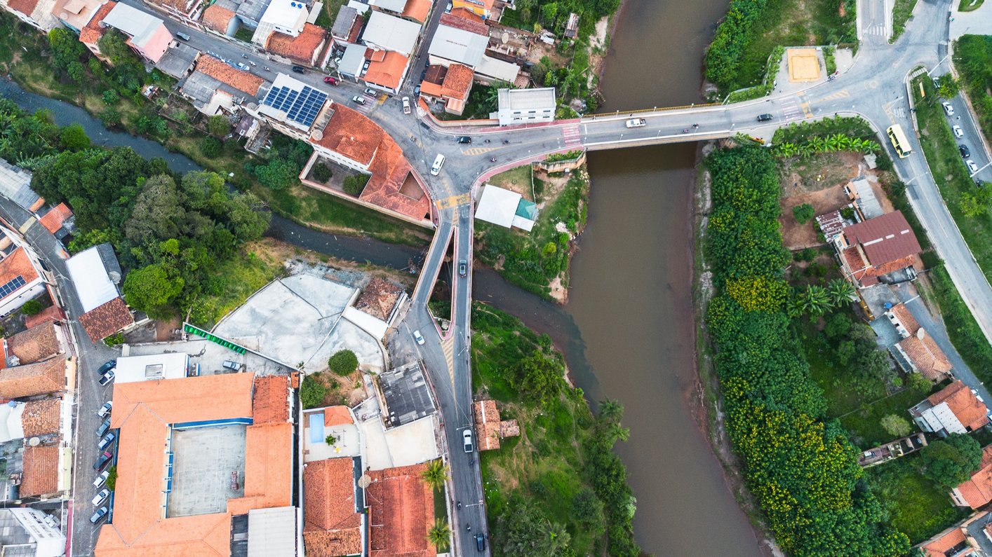 Vista aérea de Raposos (MG) — ponte sobre o Rio das Velhas atravessando o tecido urbano